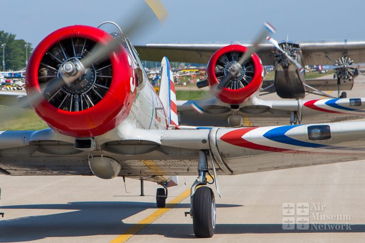 Geico Skytypers being followed by a Ford Tri-motor at EAA's AirVenture 2018 - photo by David Eckert -Air Museum Network