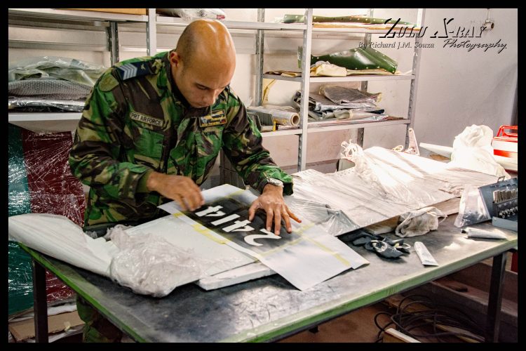 Primeiro Sargento (Master Sergeant) Fernandes prepares to paint the aircraft tail number
